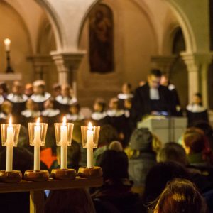 Fünf erleuchtete Kerzen und im Hintergrund ein singender Chor