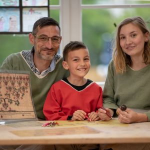 Ein Mann, eine Frau und ein kleiner Junge gestalten ihren eigenen Stammbaum nach historischem Vorbild.