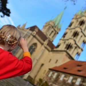 Ein Mädchen steht vor dem Naumburger Dom